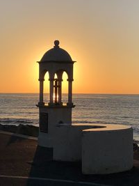 Rear view of sea against clear sky during sunset