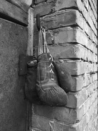 Pair of old boxing gloves hanging on brick wall