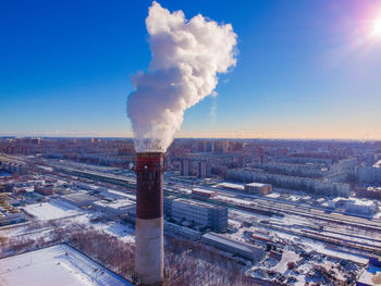 Smoke emitting from chimney against sky