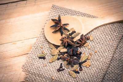 High angle view of spice with wooden spoon and jute on table