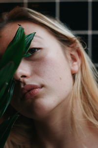 Close-up portrait of young woman by leaves