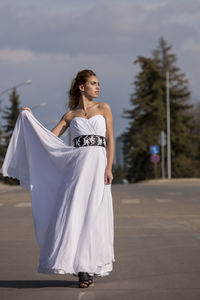 Young woman looking at camera against sky