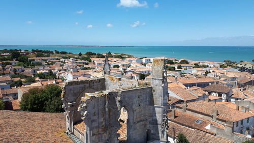 High angle view of townscape by sea against sky