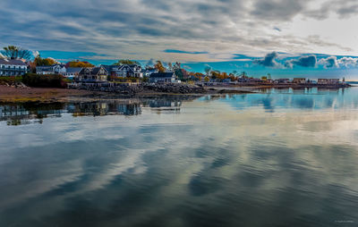 Scenic view of sea by buildings against sky