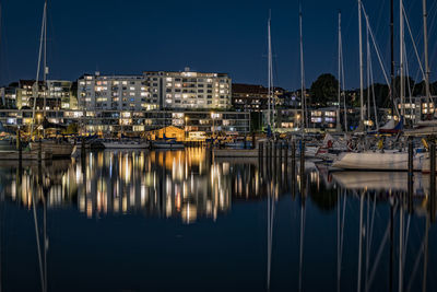 Illuminated buildings reflection in sea at night