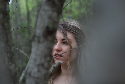 Portrait of woman looking away in forest