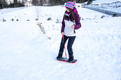 Full length of woman snowboarding on snow