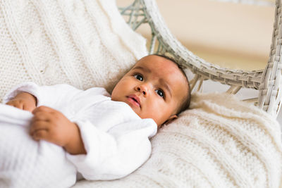 Portrait of cute baby lying on bed