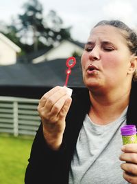 Close-up of mature woman blowing bubble 