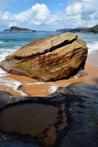 Scenic view of rocks on beach against sky