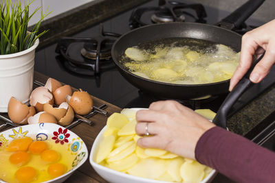 Cropped image of hands preparing food in kitchen at home