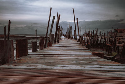 Wooden pier amidst sea against sky