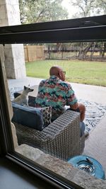 Rear view of man sitting on sofa