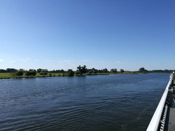 Scenic view of river against clear blue sky