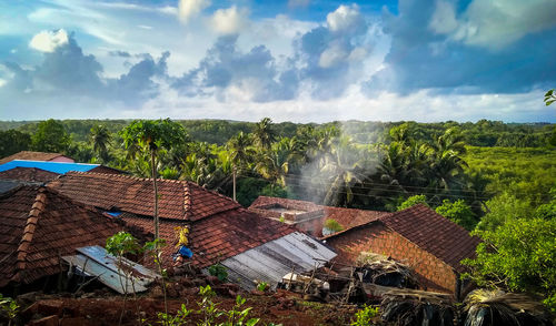 Panoramic view of houses and trees on field against sky