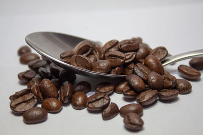 Close-up of roasted coffee beans against white background