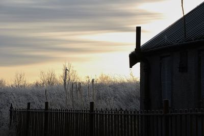 Built structure against cloudy sky at sunset