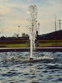 Water splashing in fountain against sky