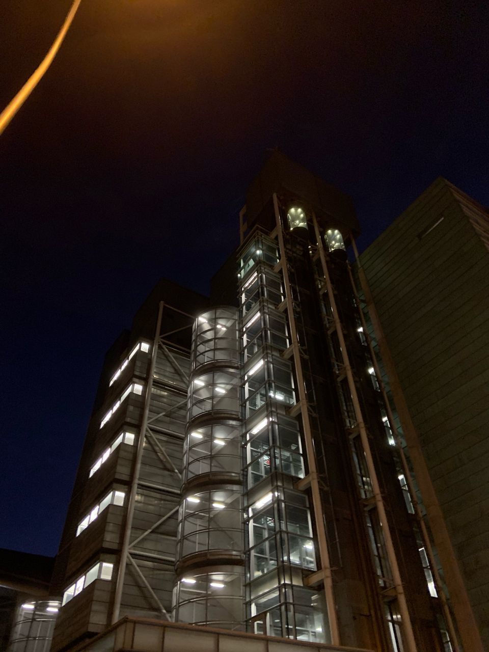 LOW ANGLE VIEW OF ILLUMINATED BUILDINGS AGAINST SKY AT NIGHT IN CITY