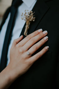Cropped hand of bride on groom blazer