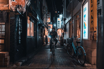 People on street amidst buildings at night