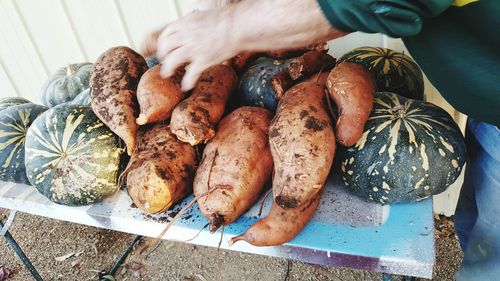 High angle view of hand holding sweet potato on table