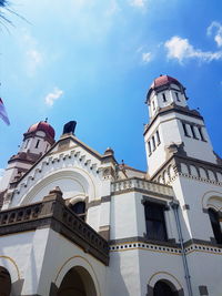 Low angle view of bell tower amidst buildings against sky