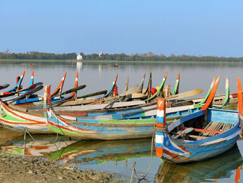 Boats moored in lake against sky