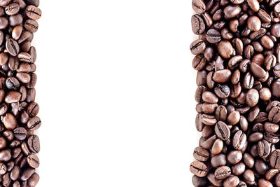 High angle view of coffee beans against white background