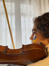 Side view of young woman sitting at home