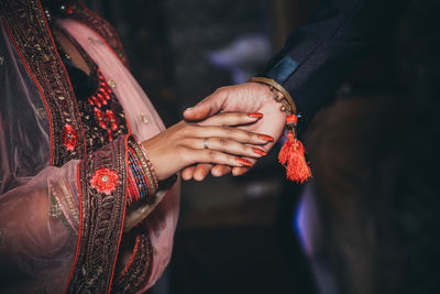 Midsection of newlywed couple holding hands