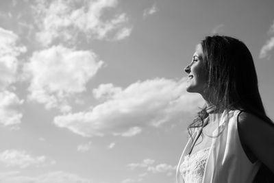 Smiling woman standing against sky