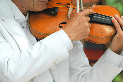 Midsection of man playing violin