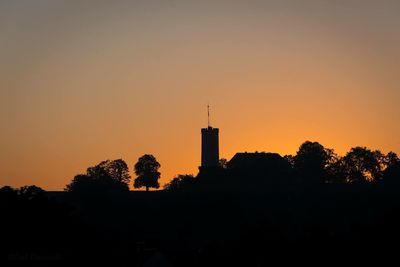 Silhouette trees against clear sky during sunset