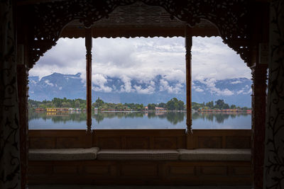 Panoramic view of lake and building seen through window