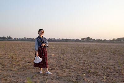 Full length of man standing on field against clear sky
