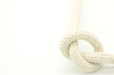 Close-up of rope tied on white background