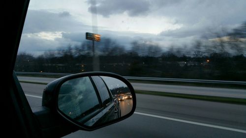 Reflection of clouds in side-view mirror