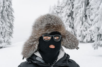 Man with ski mask in winter forest