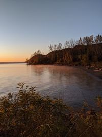 Scenic view of sea against clear sky during sunset