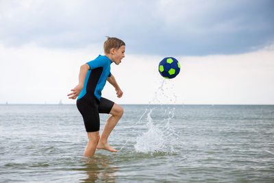 Full length of man jumping in sea against sky