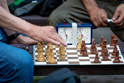 Midsection of men playing chess on board