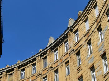 Low angle view of buildings against clear blue sky