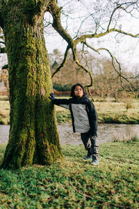 Portrait of man standing on tree trunk