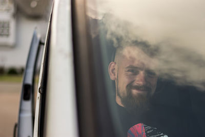 Portrait of smiling man sitting in car