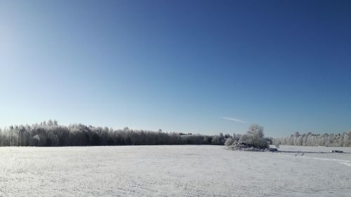 Scenic view of snowy field against clear sky