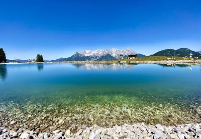 Scenic view of lake against clear blue sky