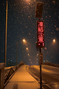 View of road sign at night