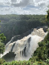 Scenic view of waterfall against sky