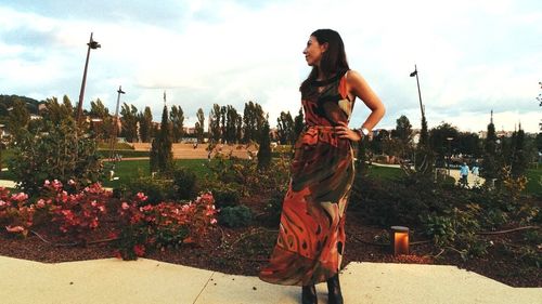 Woman standing by plants against sky